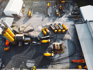 Aerial view of concrete company site with yellow trucks and other heavy machinery parked on the grounds 