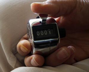 Manual counter with 0001 on its screen. Handheld counting machine. Start to count. Four-digit mechanical click counter.