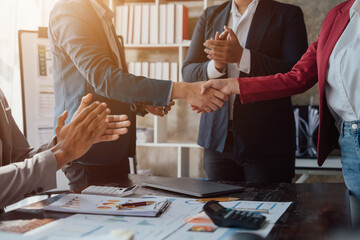 Group business workers handshake at meeting at office meeting room, from joint investment and success in the project after meeting stock market project.