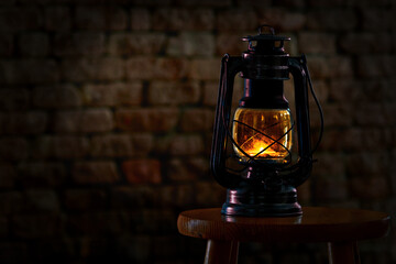 Old lantern in front of brick wall
