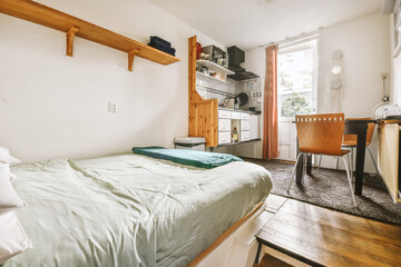 a bedroom with a bed, desk and shelves on the wall next to an open door that leads to another room