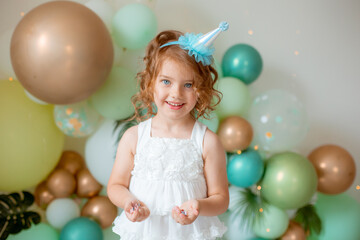 Obraz na płótnie Canvas little girl celebrating birthday catches confetti