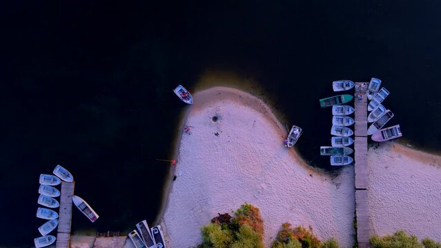 Drone flight over fishing boats and fishermen on the river bank
