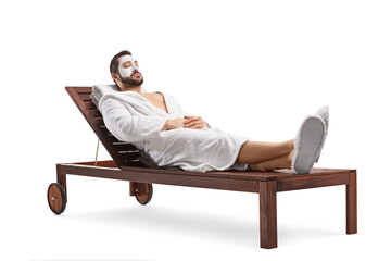Man in a bathrobe with a face mask laying on a lounge chair