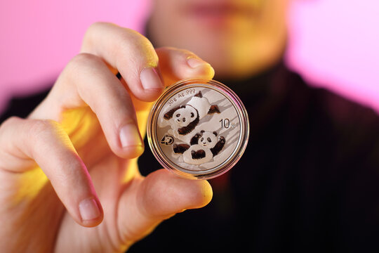 silver yuan coin with pandas on the obverse face value 10 held in the hand