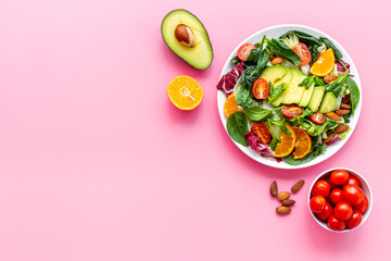 Overhead view of cooking healthy green salad with avocado and tomatoes