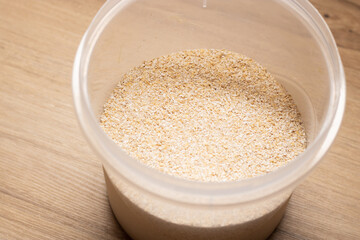 Close up oat grains in transparent container. High quality photo on wooden table