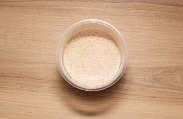 Grain oats in transparent container. High quality photo on wooden table