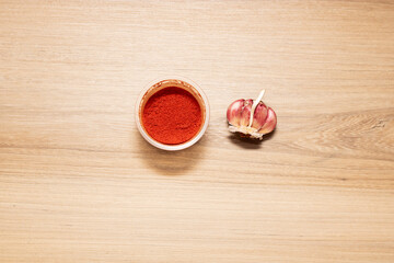 Paprika powder and garlic clove for seasoning. High quality photo on wooden table