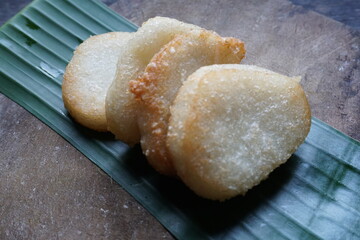 Jadah goreng or Fried sticky rice cake is Javanese traditional cake made from glutinous rice and grated coconut on a wooden cutting board.