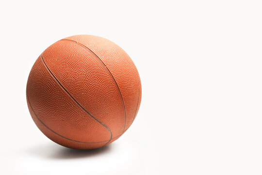 Pelota de baloncesto sobre un fondo blanco liso y aislado. Vista de frente y de cerca. Copy space