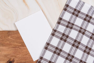 white paper on wood table on marble background with checkered cloth
