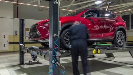 Car on stand with sensors on wheels for wheels alignment camber check in workshop of Service station timelapse. Car moves on lift
