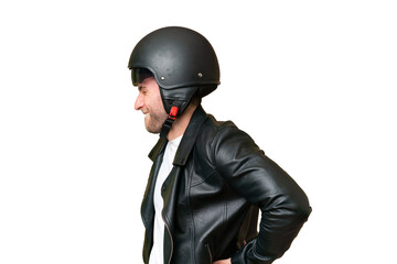 Young caucasian man with a motorcycle helmet isolated on green chroma background suffering from...