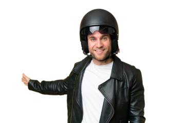 Young caucasian man with a motorcycle helmet isolated on green chroma background extending hands to the side for inviting to come
