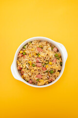 Rice with corn. peas, ham on white bowl