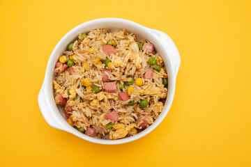 Rice with corn. peas, ham on white bowl