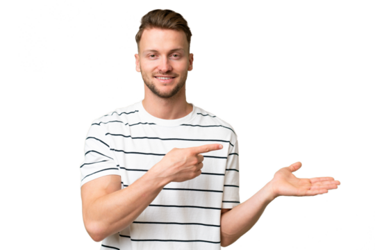 Young blonde caucasian man over isolated background holding copyspace imaginary on the palm to insert an ad