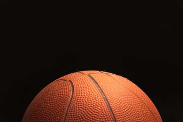 Pelota de baloncesto sobre un fondo negro  liso y aislado. Vista de frente y de cerca. Copy space