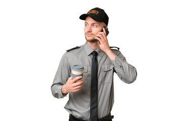 Young security caucasian man over isolated background holding coffee to take away and a mobile