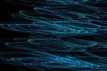 Imagenes de luces color azul abstractas en forma de ondas en un fondo negro © Paul