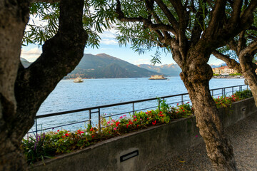 View from the lakefront promenade of the mountains and Lake Como with boats and ferries in the...