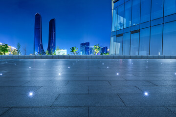 Empty square floor and modern city skyline with buildings at night in Hangzhou, China.
