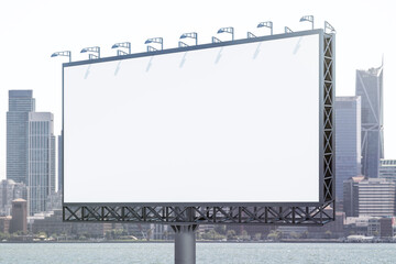 Blank white horizontal billboard on city buildings background at daytime, perspective view. Mockup, advertising concept