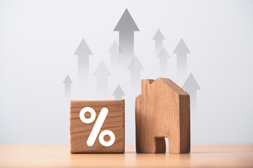 Percentage and wooden house model with up arrow for interest rating mortgage increasing concept.