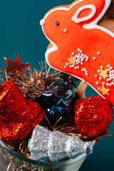 Naklejka premium Glass with Christmas decorations on dark green background