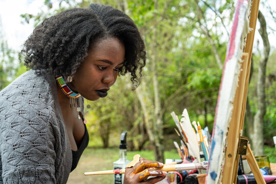 woman focused on her painting in the garden
