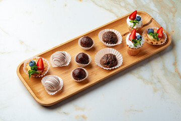 Sweets platter on banquet table with cocolate candies and cupcakes