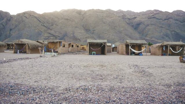 A Small Settlement In A Desert Mountain Area With Reed Huts