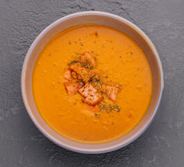 Carrot, pumpkin cream soup with salmon
