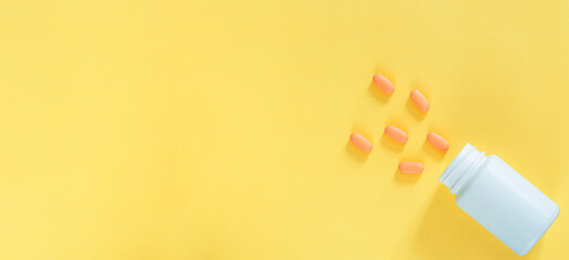 Pills and pill bottles on yellow background,Brown medical glass drug bottle and some pills around with a cap on yellow,Erlenmeyer Flask. Empty Glass Conical Lab Container