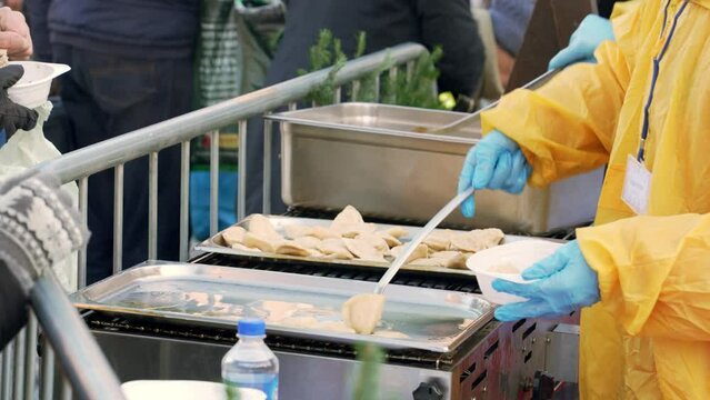 On a frosty winter day on the streets of Krakow, volunteers of the charitable organization feed everyone in need with hot meals for free, tradition of selfless help to those in need before Christmas