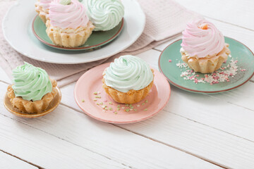 cupcakes on plates on white wooden background