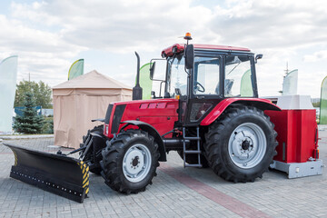 Red wheeled tractor with mouldboard at an agricultural fair