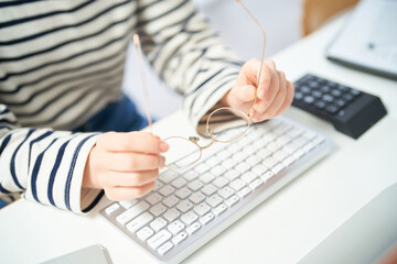 メガネをかけてデスクに向かう若い女性