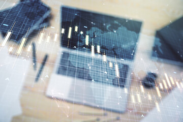 Multi exposure of abstract creative financial chart with world map on laptop background, research and analytics concept