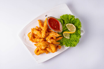 fried chicken meat with tomato sauce on a white background