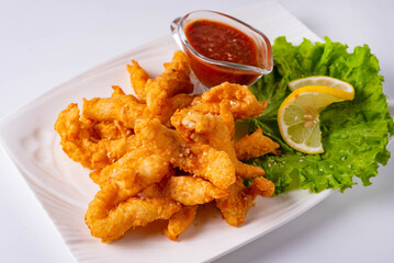 fried chicken meat with tomato sauce on a white background