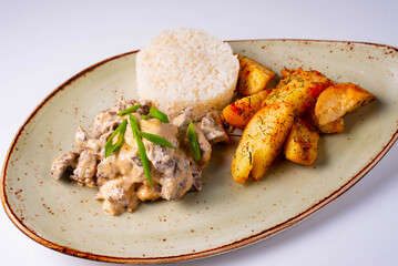 mushrooms in sauce with potatoes and rice on a white background