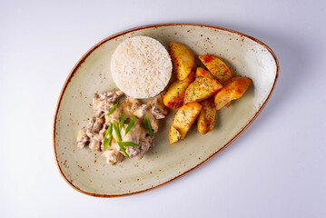 mushrooms in sauce with potatoes and rice on a white background