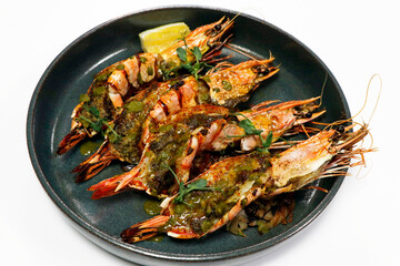 spice marinated grilled king tiger prawns or shrimps in a plate with white background