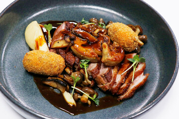 roasted duck breast slices with foie gras , mushrooms, croquettes and wine sauce