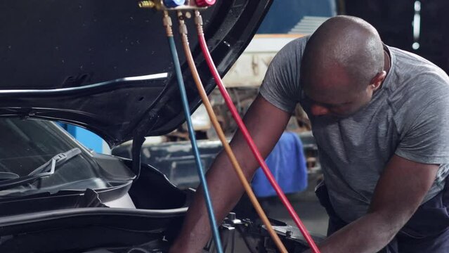 Car air conditioner check and service. Meter measuring equipment for filling air conditioners. Black mechanic man Check car air conditioning system refrigerant recharge