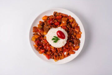 stewed vegetables with meat and boiled rice. on a white background