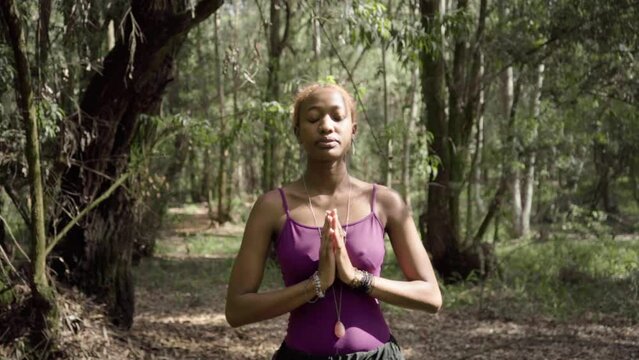 young woman doing breathing exercises in nature