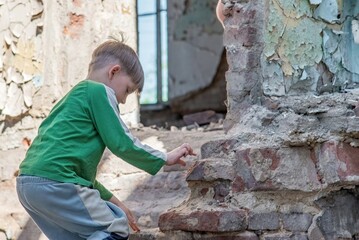 Children in an abandoned and destroyed building in the zone of military and military conflicts. The...